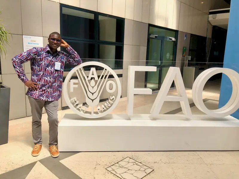 Konoutan Medard Kafoutchoni in front of the FAO logo at the Rome headquarters